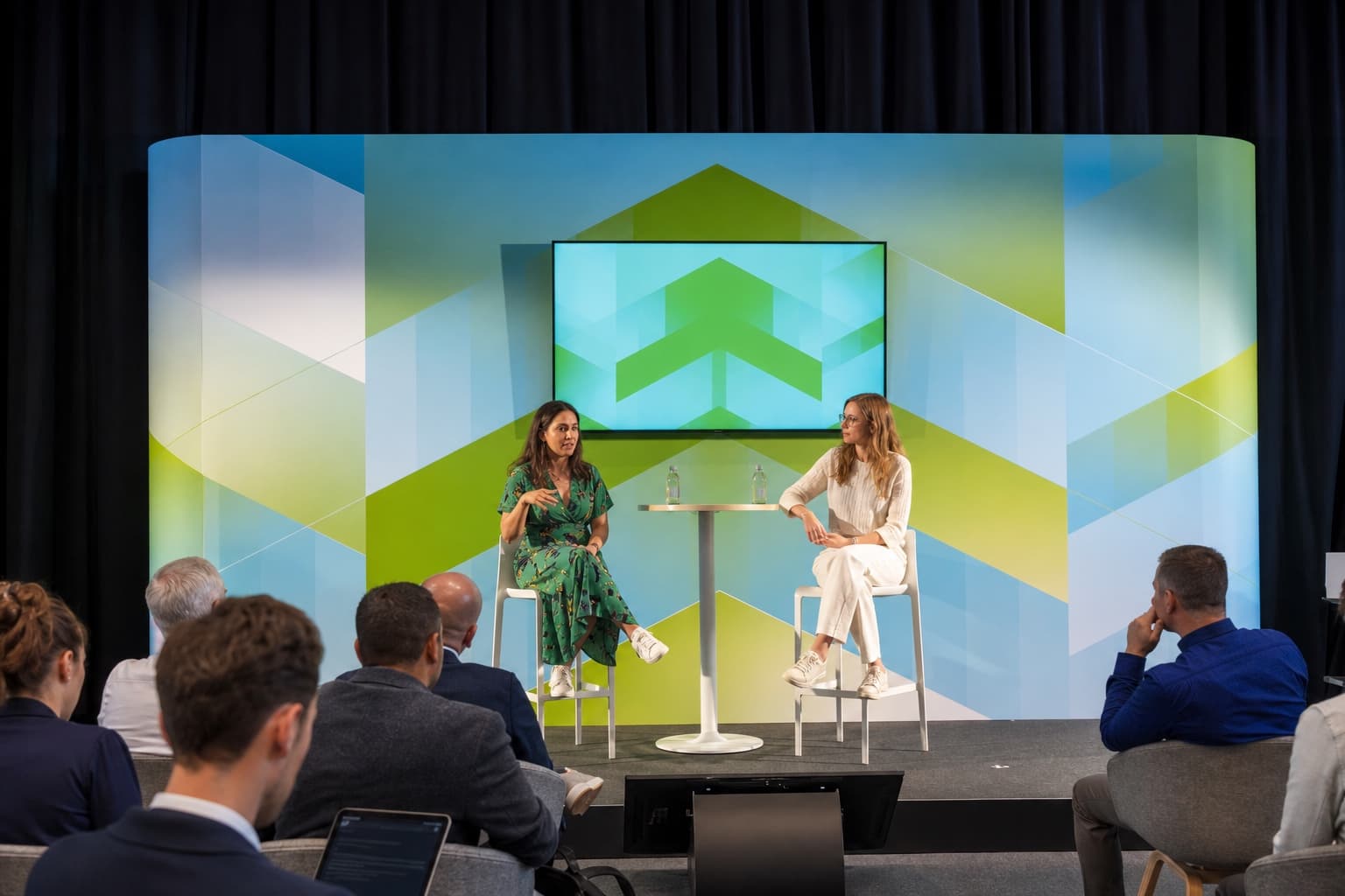 An anonymized conference panel photographed from the audience.