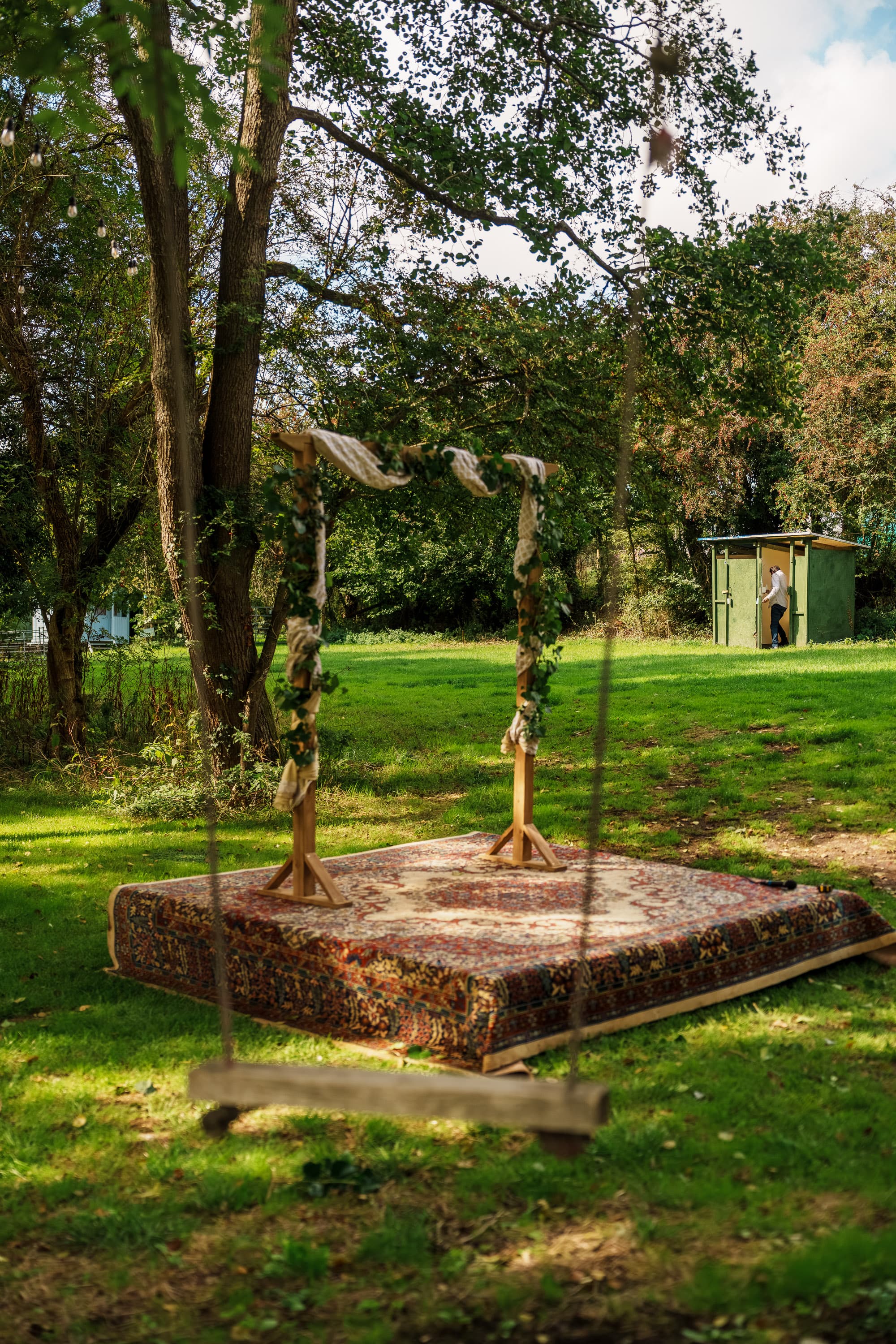 The ceremony arch and swing sitting ready in the open air before anyone takes their place.