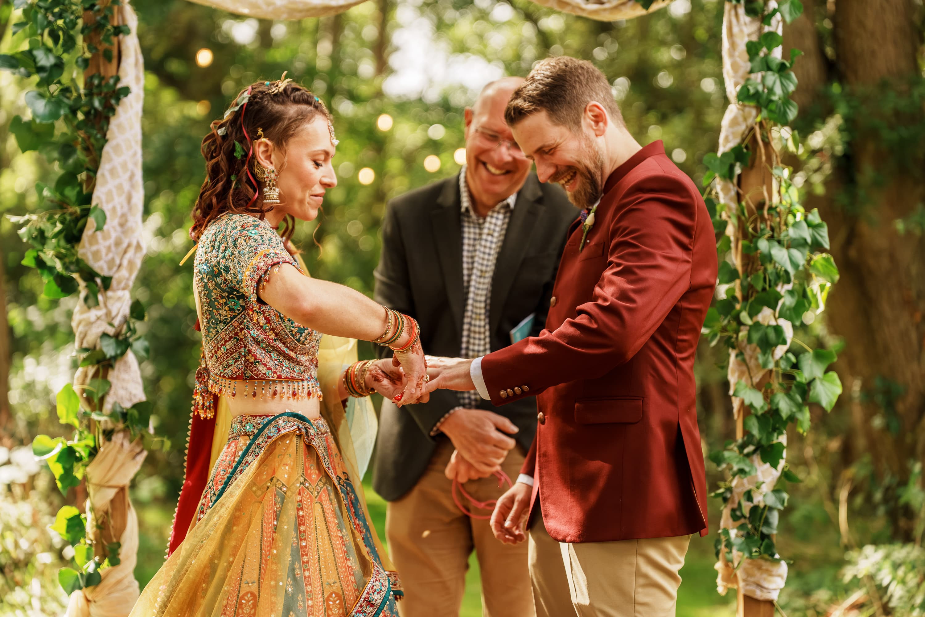 Adam and Sarah exchanging rings in the open air while everyone witnesses the promise.