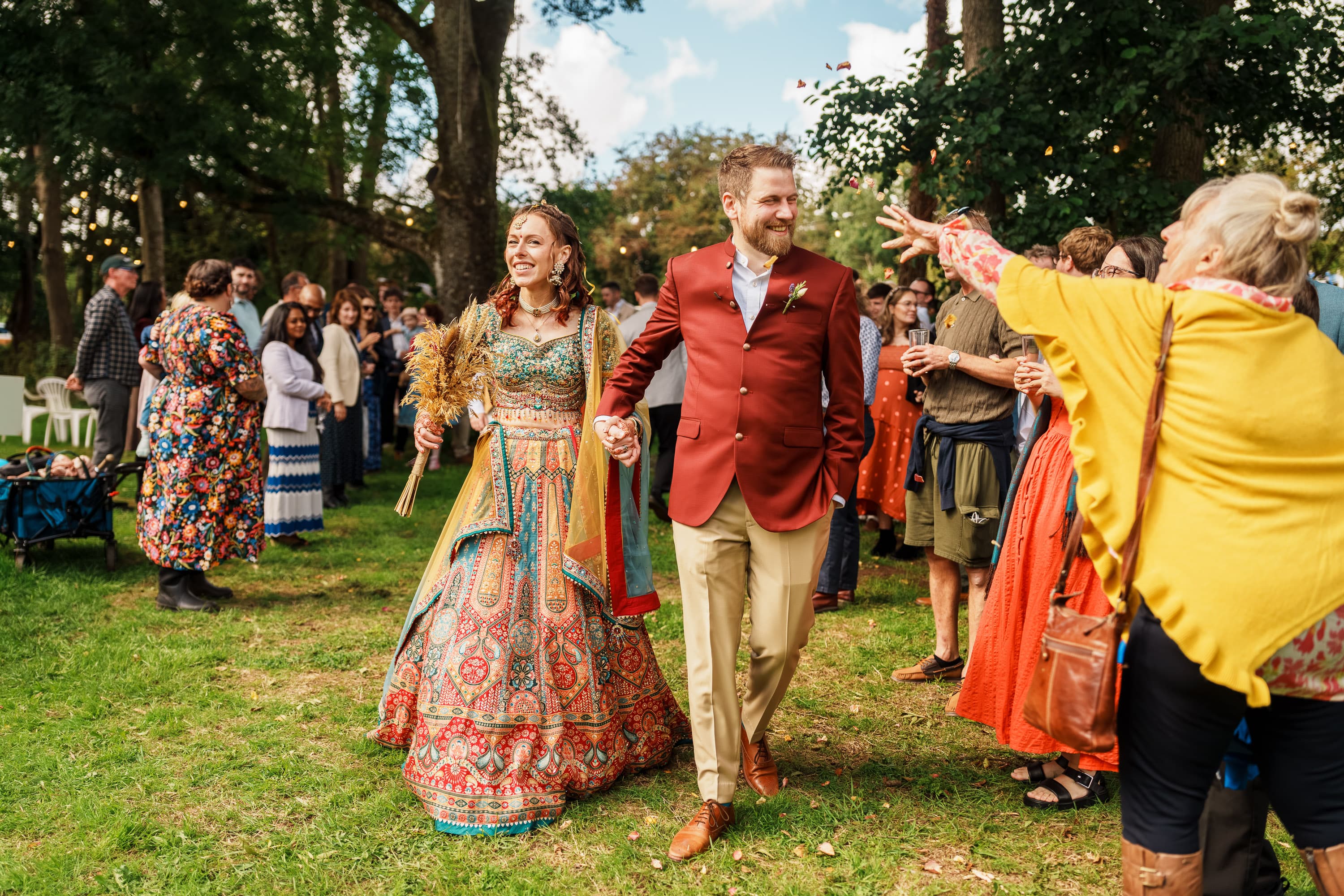 A wedding couple walking out through guests as the ceremony opens into celebration.