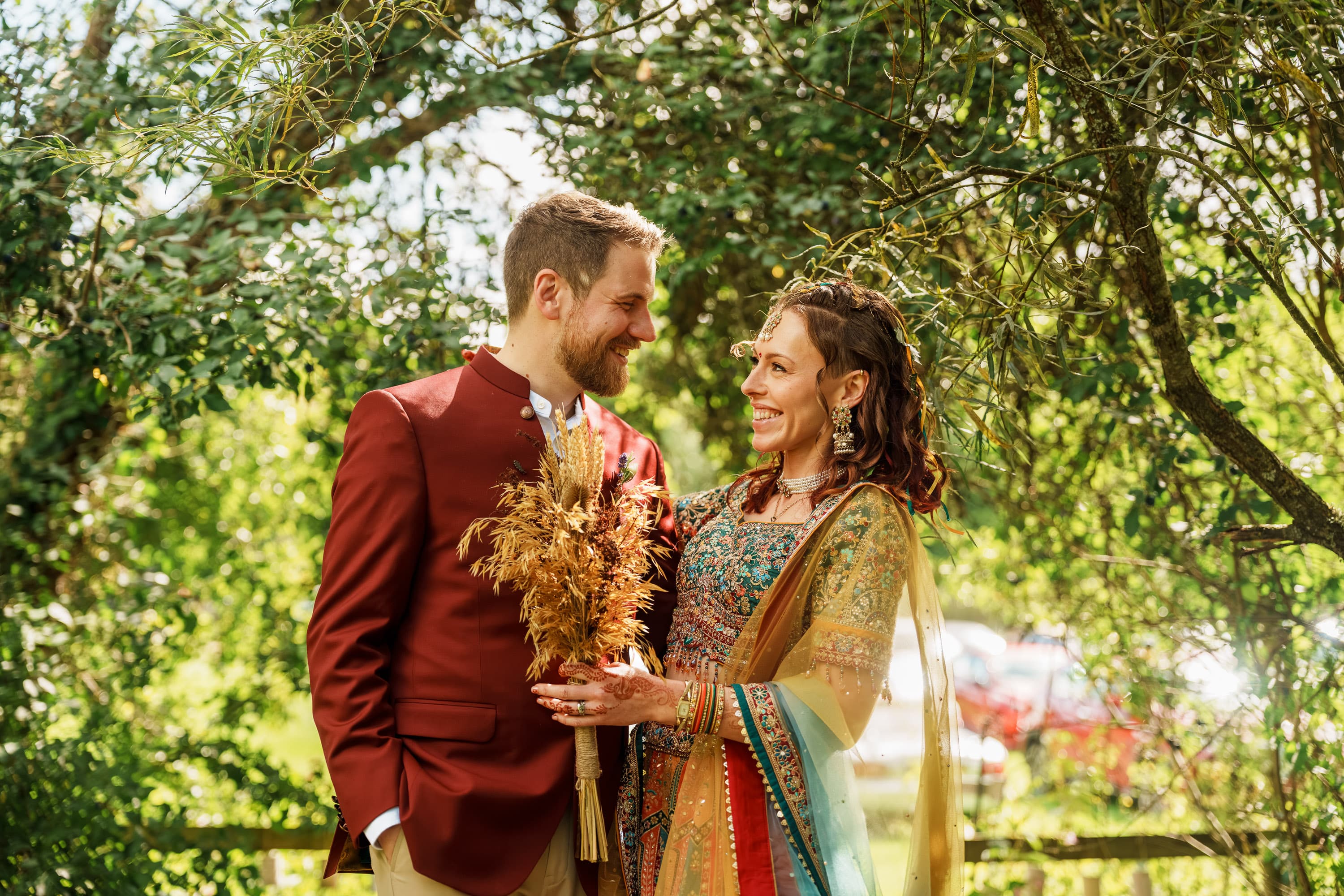 Adam and Sarah holding a quieter portrait beneath the trees once the ceremony has opened out behind them.