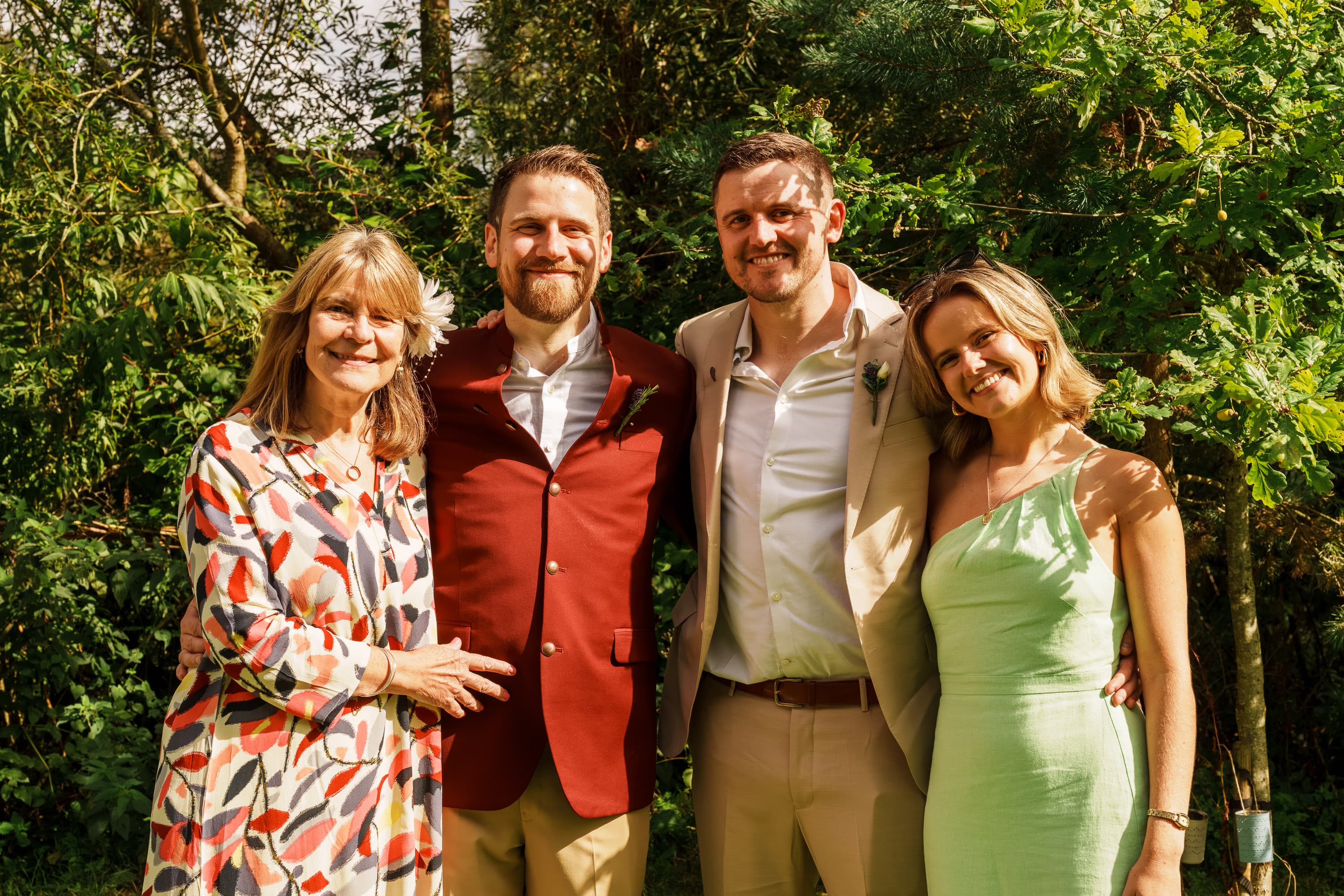 Adam with close family in a relaxed portrait that keeps the wedding socially grounded.