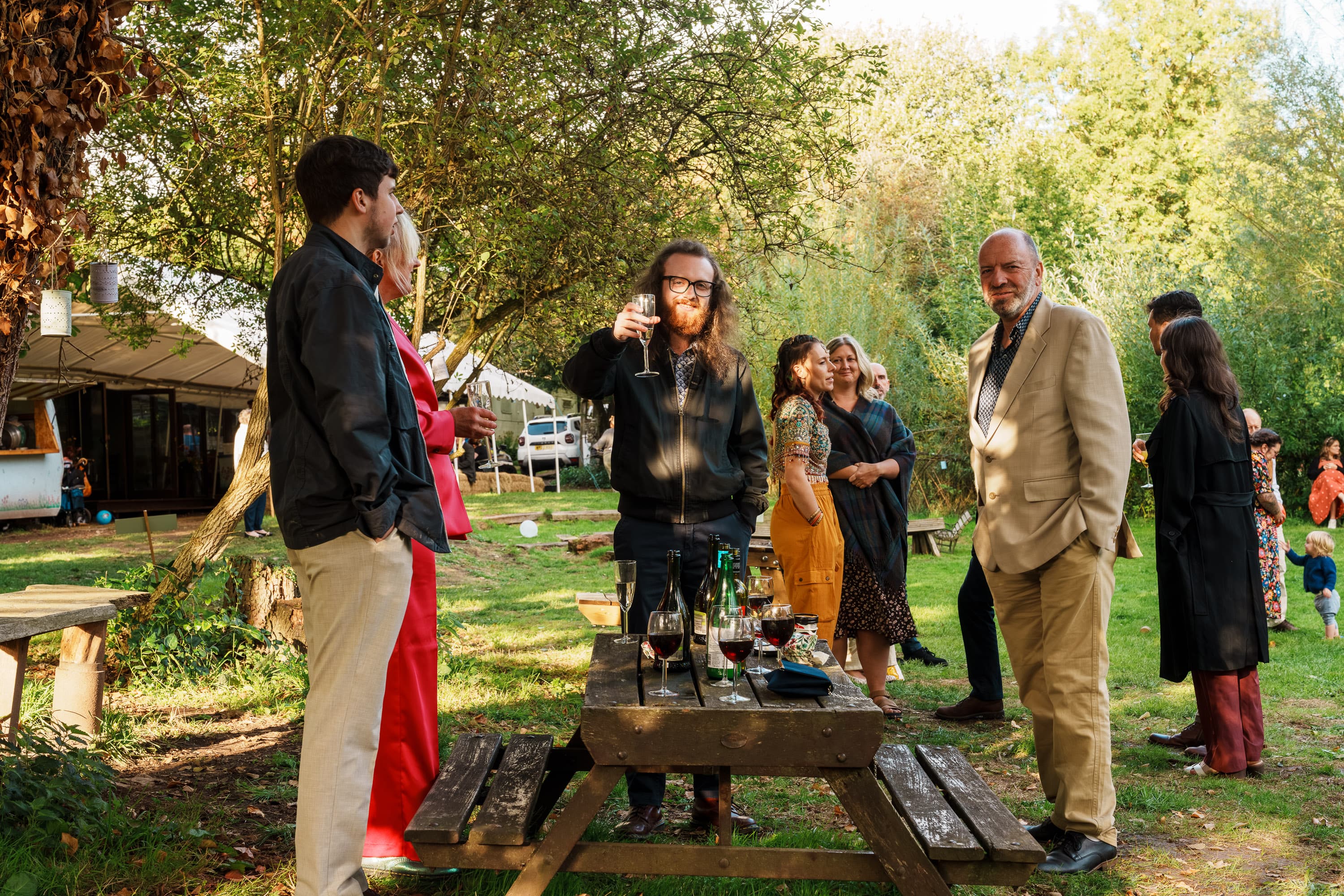 Guests talking outside as the afternoon settles into a warmer, looser social rhythm.