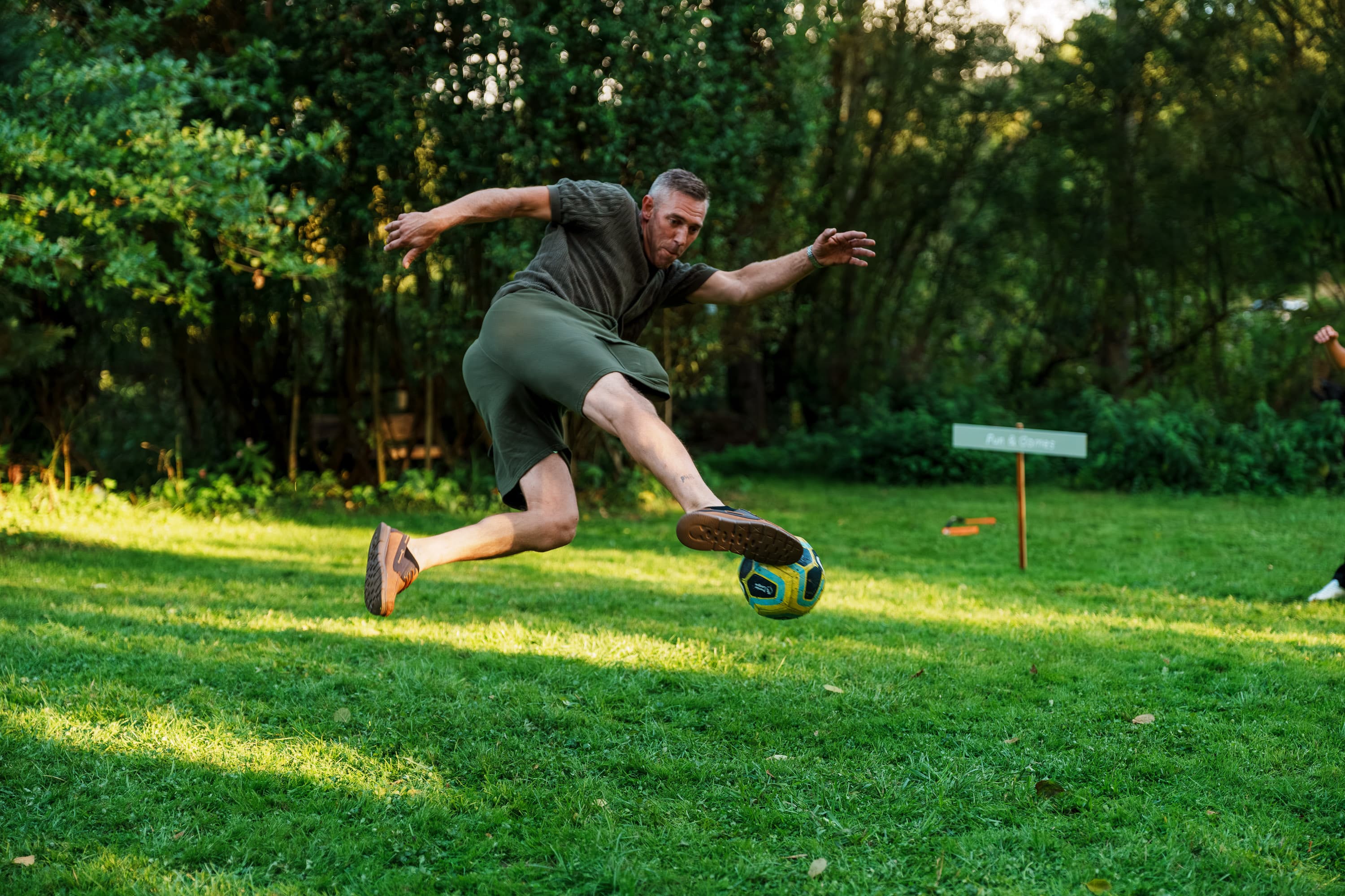 A guest throwing himself into a football game as the afternoon becomes more playful.
