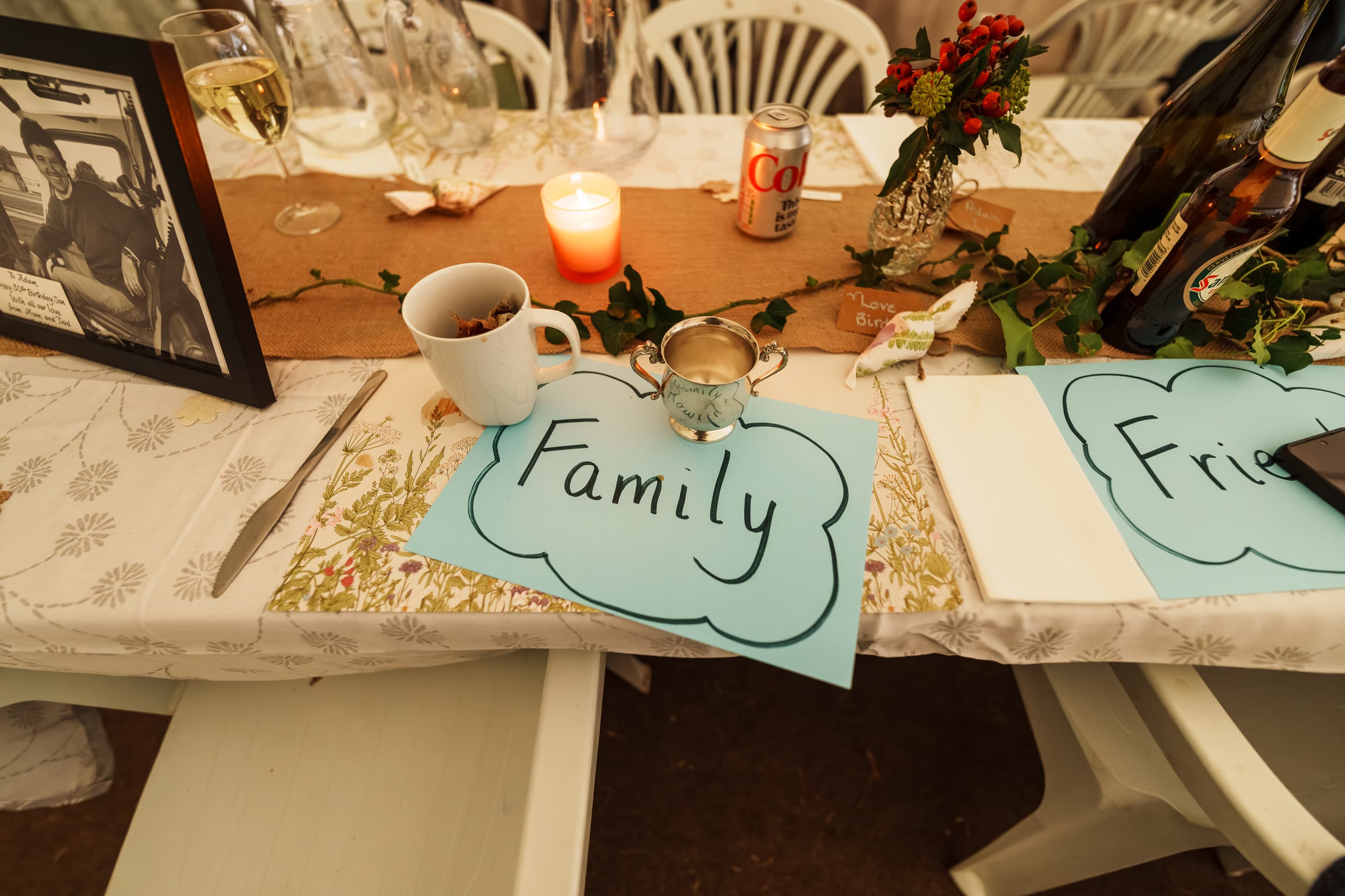 A family table sign and lived-in tabletop details anchoring the communal feeling of the meal.