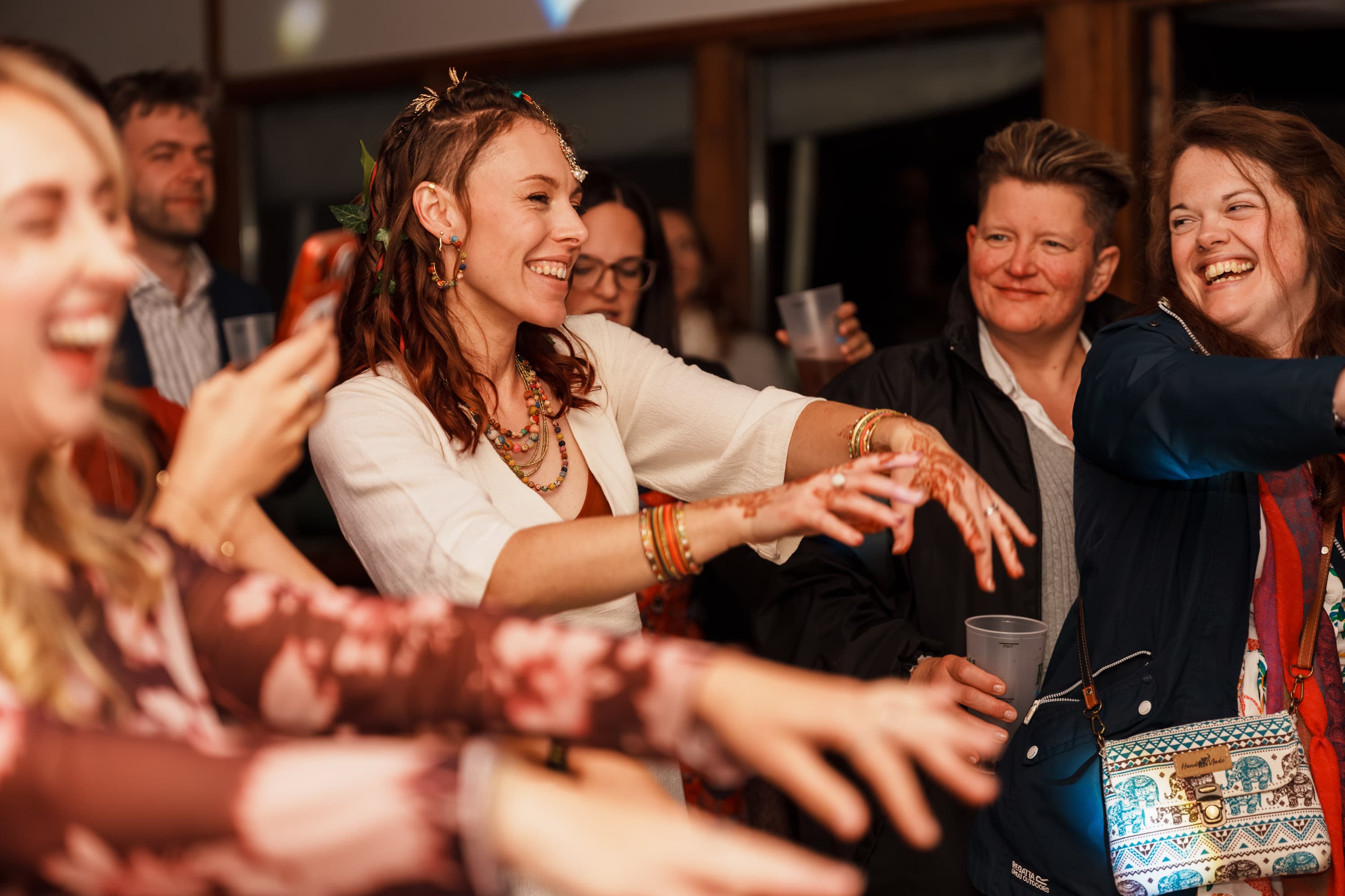 Sarah laughing with guests as the room loosens into a fuller late-night communal energy.