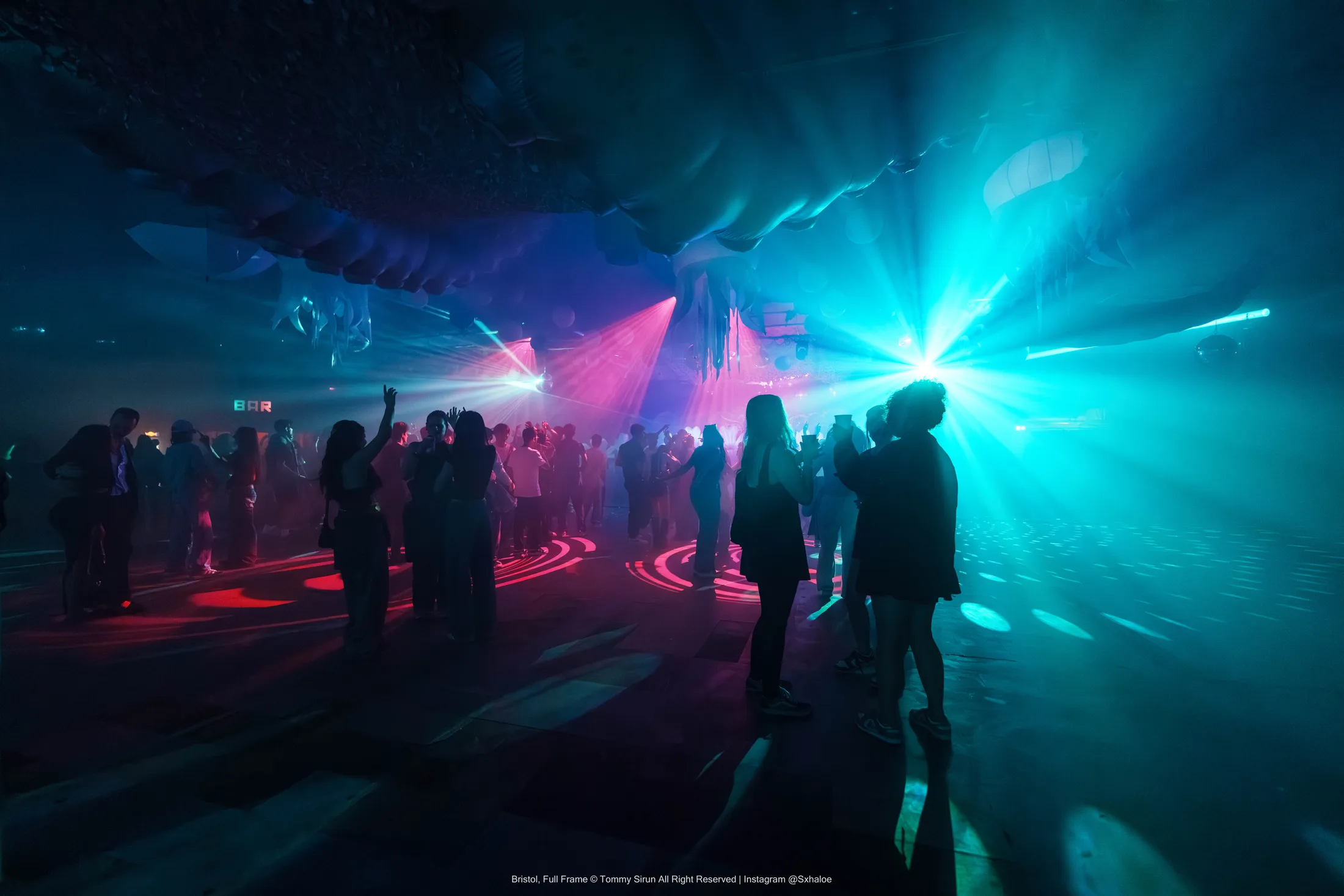 A nightlife atmosphere frame balancing flash, ambient light, and crowd depth.