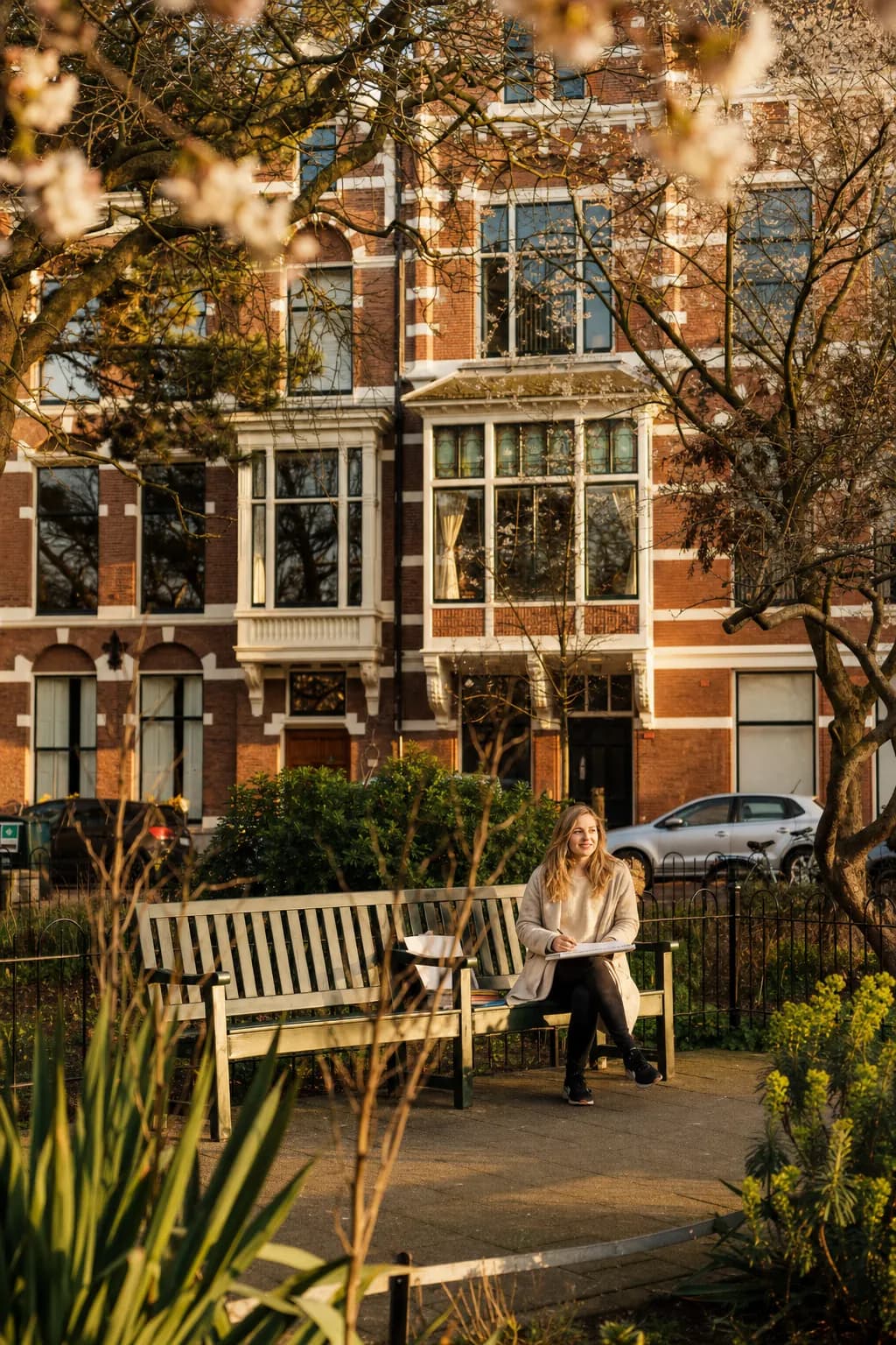 Environmental portrait with garden, city context, and calm spring light.